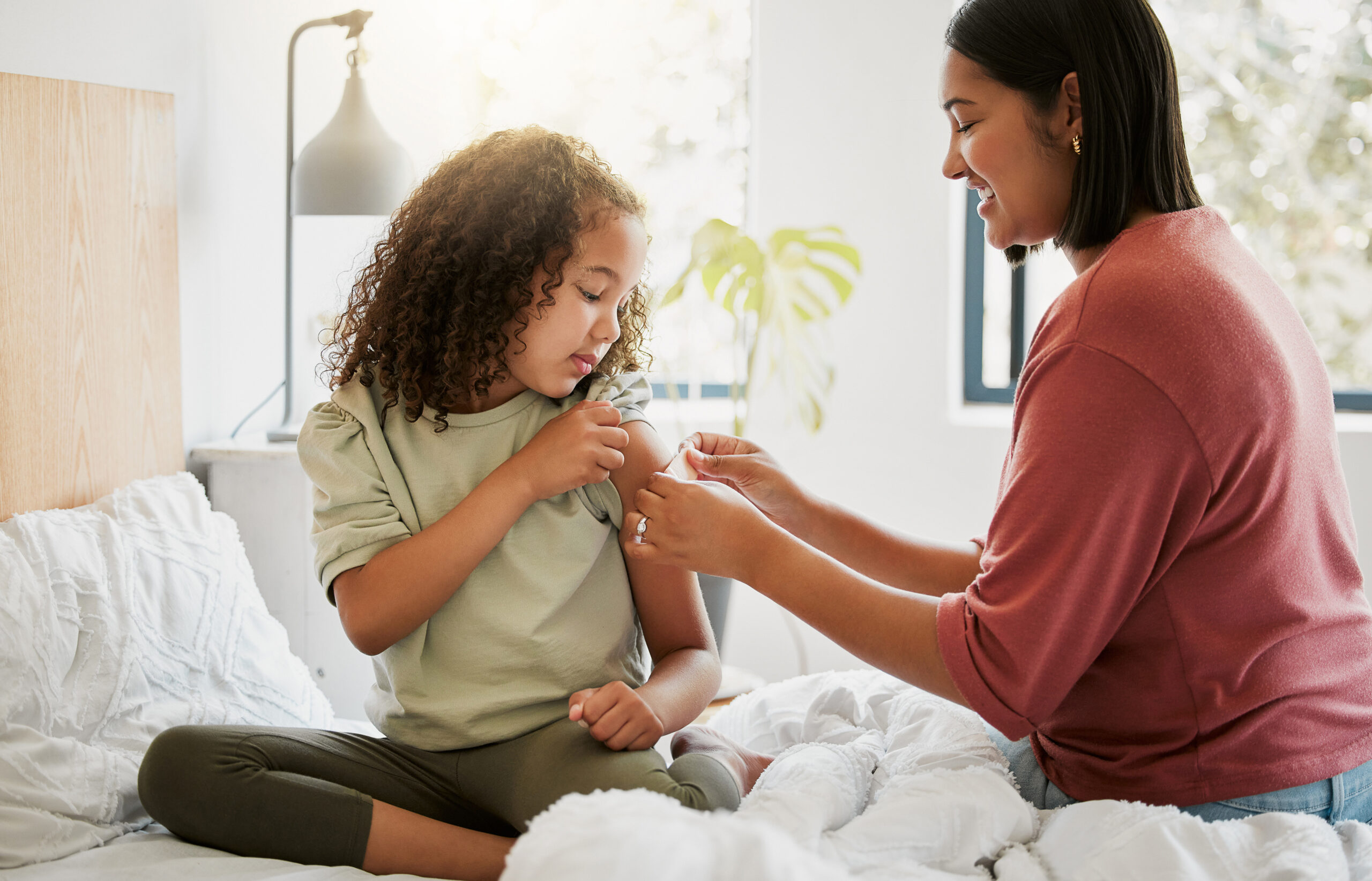 loving-mother-comforting-her-daughter-with-bandaid-bed-being-affectionate-caring-home-young-parent-helping-her-sick-child-applying-plaster-bonding-special-moments-motherhood